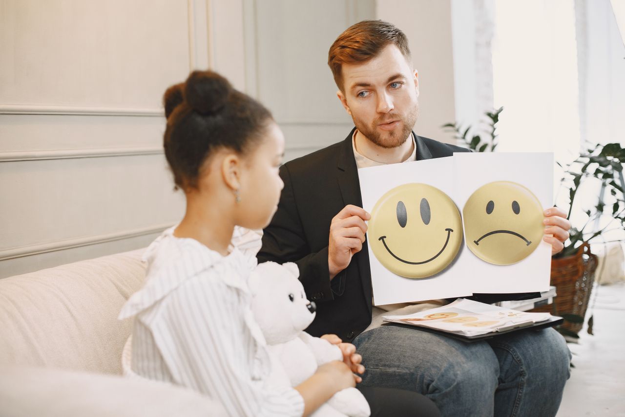 Crafting Captivating Headlines: Your awesome post title goes here A therapist uses emotion cards to help a child express feelings during a counseling session.